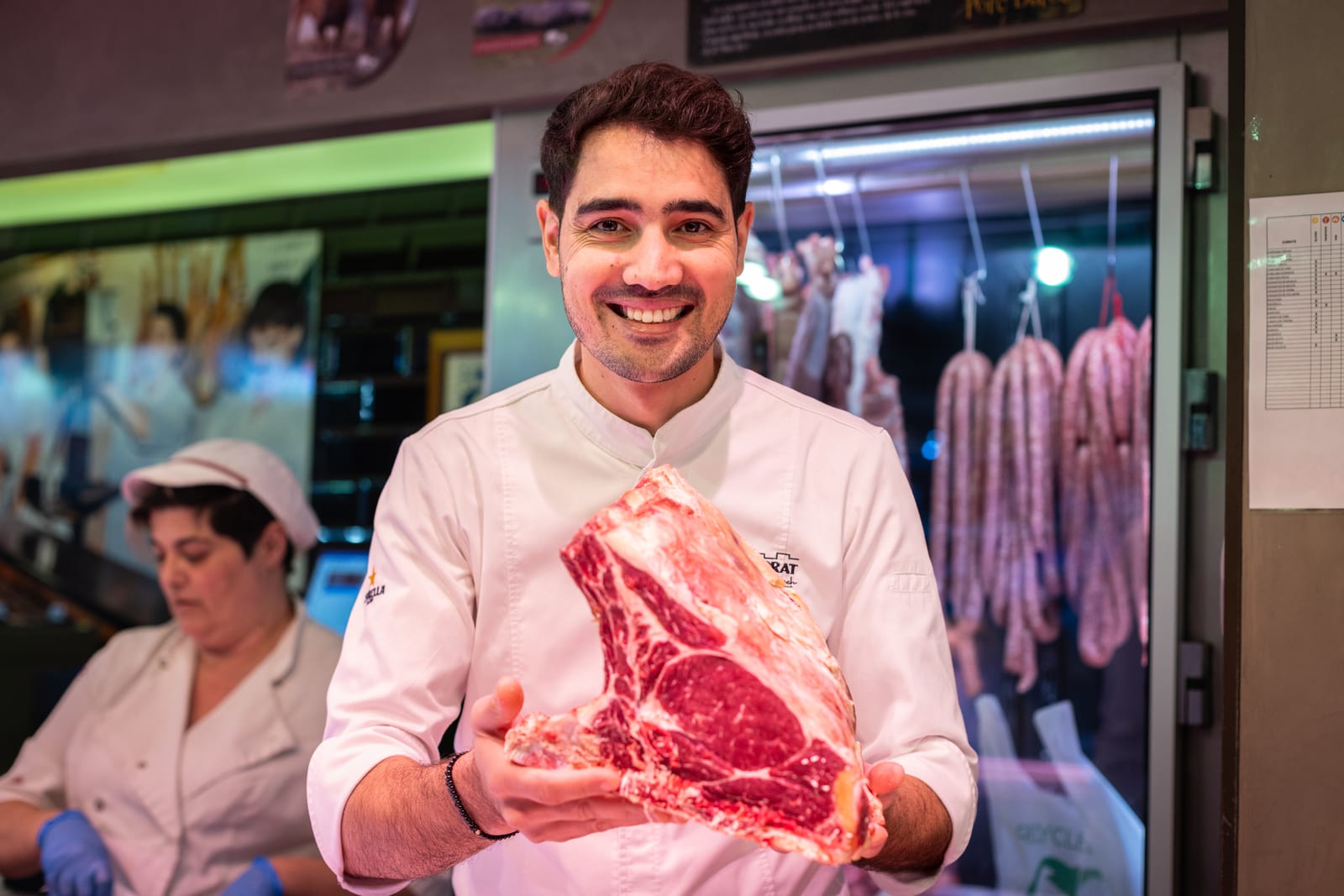 Moha Quach avec une pièce de viande à la boucherie du Mercat Central